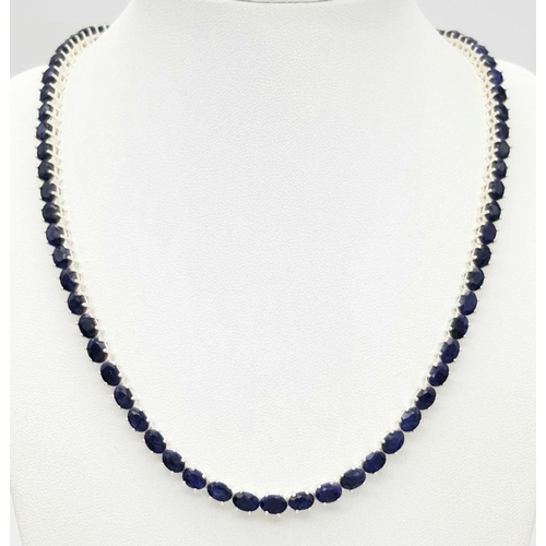 114 - A Blue Sapphire Tennis Necklace. Set in 925 Silver. 44cm. CD-1601