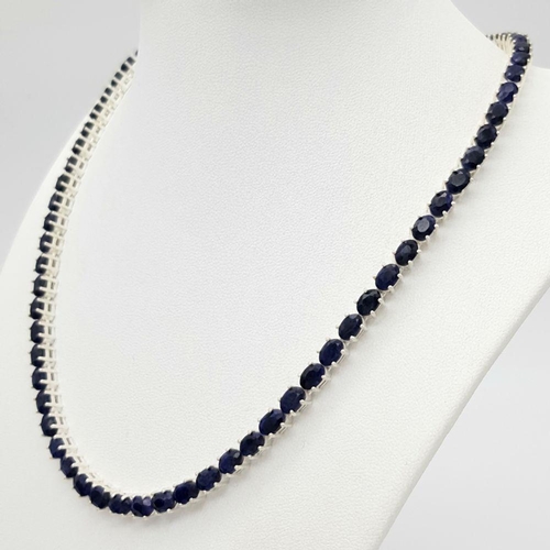 114 - A Blue Sapphire Tennis Necklace. Set in 925 Silver. 44cm. CD-1601