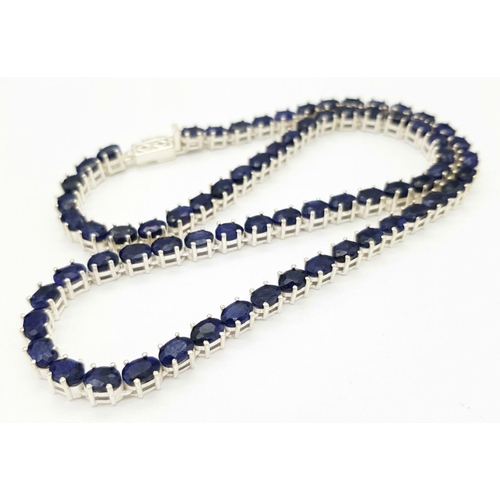 114 - A Blue Sapphire Tennis Necklace. Set in 925 Silver. 44cm. CD-1601