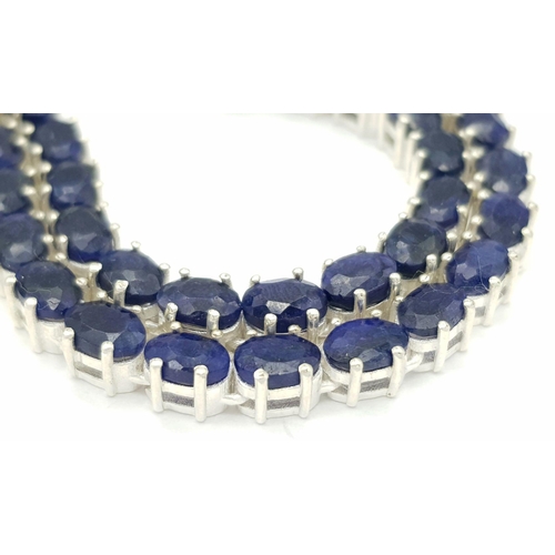 114 - A Blue Sapphire Tennis Necklace. Set in 925 Silver. 44cm. CD-1601