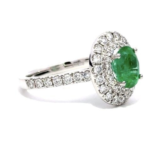 211 - A Platinum Cluster Ring, featuring a 1.27ct Oval Emerald surrounded by a halo of Round Brilliant-Cut... 