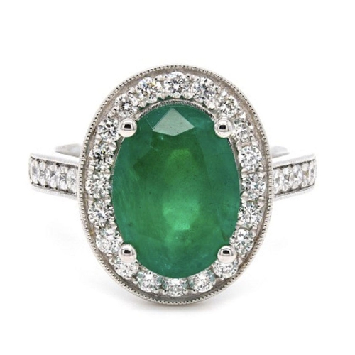 407 - A Platinum Cluster Ring, featuring a 2.07ct Oval Emerald surrounded by a halo of Round Brilliant-Cut... 