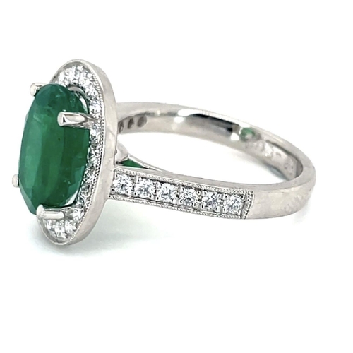 407 - A Platinum Cluster Ring, featuring a 2.07ct Oval Emerald surrounded by a halo of Round Brilliant-Cut... 