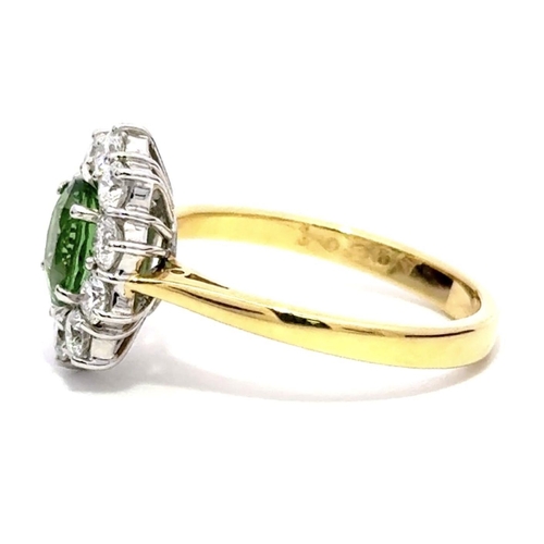 421 - An 18K Yellow & White Gold Cluster Ring, featuring a 1.30ct Oval Tsavorite surrounded by a halo of R... 