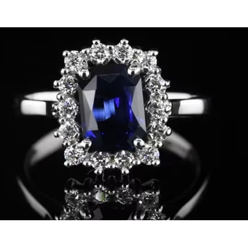 589 - A Platinum Cluster Ring, featuring a 2.05ct Emerald-Cut Blue Sapphire surrounded by a halo of Round ... 