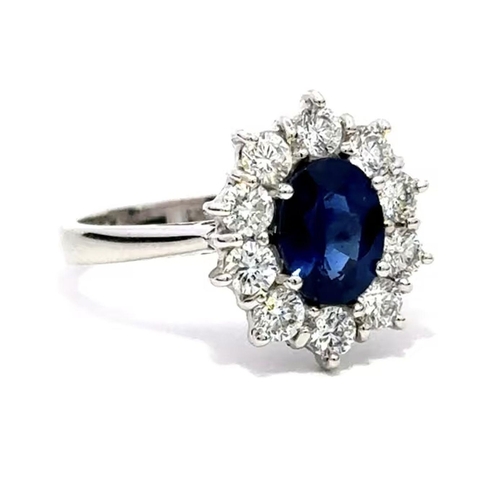 603 - A Platinum Cluster Ring, featuring a 1.43ct Oval Blue Sapphire surrounded by a halo of Round Brillia... 