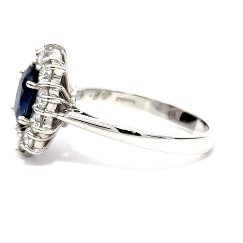 603 - A Platinum Cluster Ring, featuring a 1.43ct Oval Blue Sapphire surrounded by a halo of Round Brillia... 