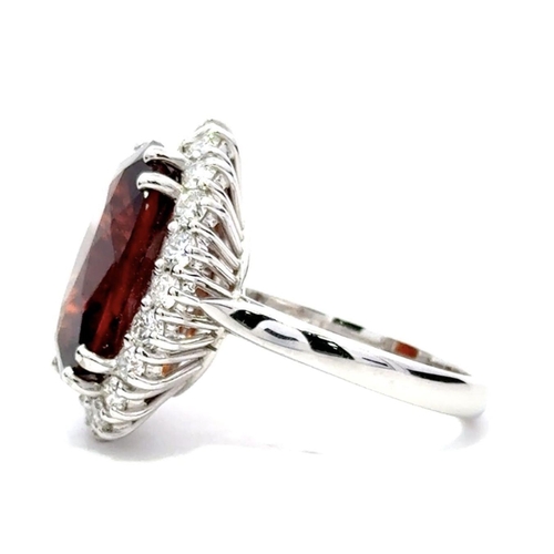 631 - An 18K White Gold Cluster Ring, featuring a 10.41ct Oval Hessonite Garnet surrounded by a halo of Ro... 