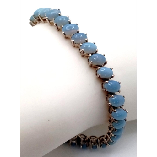 633 - A Unique Sterling Silver Blue Chalcedony Tennis Bracelet-21.5cm Length. Set with Forty-Two 6mm Oval ... 