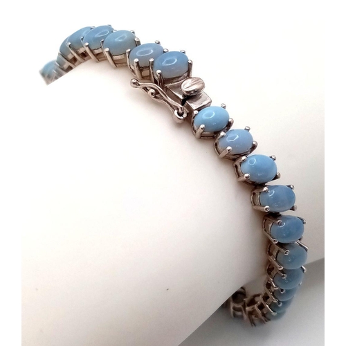 633 - A Unique Sterling Silver Blue Chalcedony Tennis Bracelet-21.5cm Length. Set with Forty-Two 6mm Oval ... 