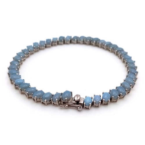 633 - A Unique Sterling Silver Blue Chalcedony Tennis Bracelet-21.5cm Length. Set with Forty-Two 6mm Oval ... 