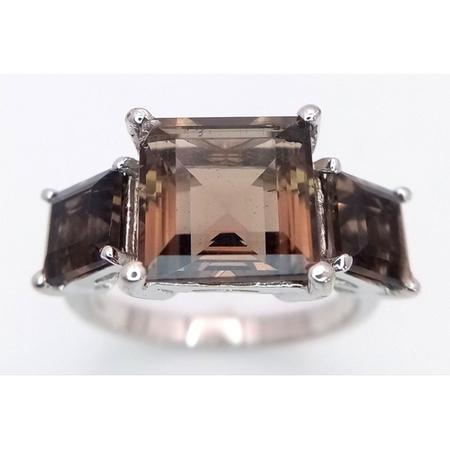 990 - A Sterling Silver Smoky Quartz Trilogy Ring Size R. The Centre Stone Measures 1cm Square and the Thr... 