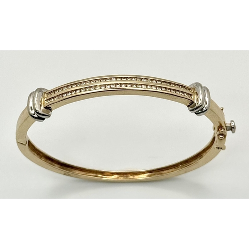 121 - A Stylish 9K Yellow and White Gold, Diamond Bangle. 62 small round cut diamonds over two levels. Cli... 