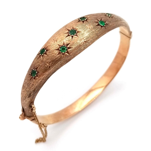 16 - A 9K YELLOW GOLD VINTAGE EMERALD SET BANGLE. 15.1G TOTAL WEIGHT, 6CM INNER DIAMETER. HALLMARKED BIRM... 