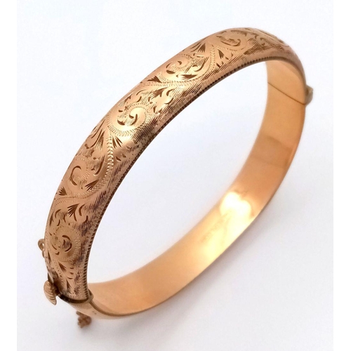 365 - A NICELY DECORATED HINGED BANGLE IN 9K GOLD METAL CORE WITH SAFETY CHAIN .    16.3gms