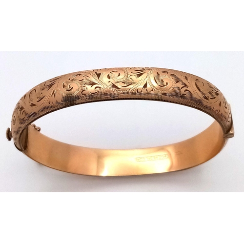 365 - A NICELY DECORATED HINGED BANGLE IN 9K GOLD METAL CORE WITH SAFETY CHAIN .    16.3gms