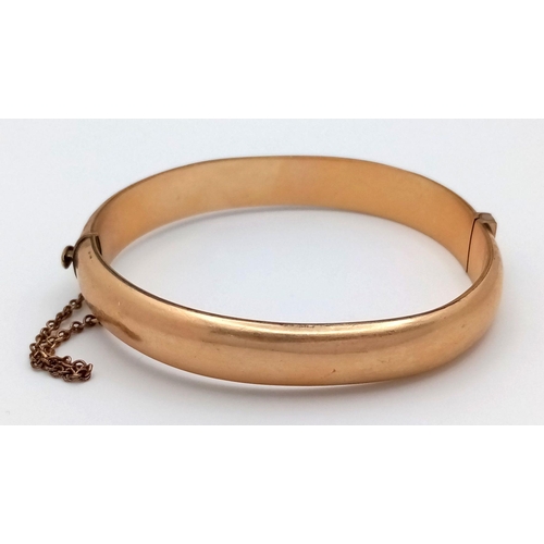 365 - A NICELY DECORATED HINGED BANGLE IN 9K GOLD METAL CORE WITH SAFETY CHAIN .    16.3gms