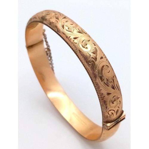 365 - A NICELY DECORATED HINGED BANGLE IN 9K GOLD METAL CORE WITH SAFETY CHAIN .    16.3gms