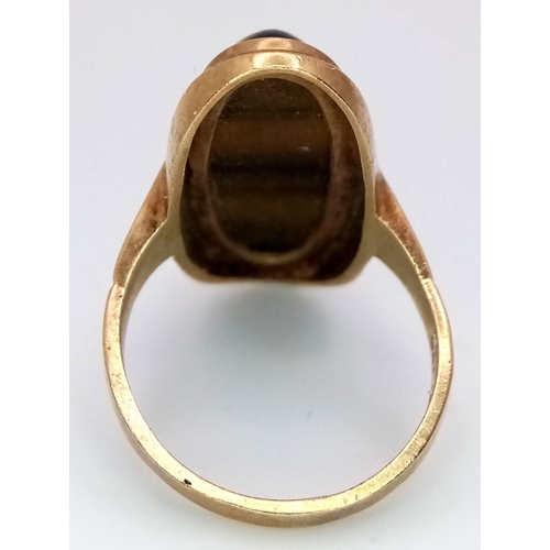 43 - A 9K GOLD DRESS RING WITH OVAL TIGERS EYE STONE ,  6.6gms    size O