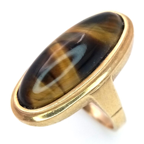 43 - A 9K GOLD DRESS RING WITH OVAL TIGERS EYE STONE ,  6.6gms    size O