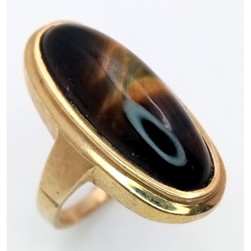 43 - A 9K GOLD DRESS RING WITH OVAL TIGERS EYE STONE ,  6.6gms    size O