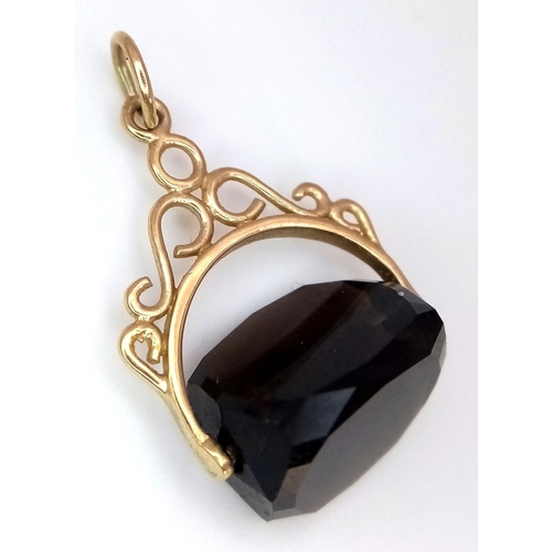 1216 - A 9K Yellow Gold Smoky Quartz Spinning Fob Pendant. 2.5cm. 3g total weight.