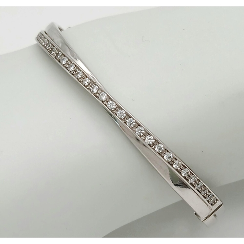 134 - A 9K White Gold White Stone Crossover Bangle. Clip design. 6cm inner diameter. 13.2g.