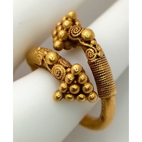 163 - An 18K Gold Etruscan Style Crossover Ring. Size F. 8.2g.