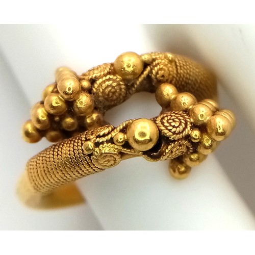 163 - An 18K Gold Etruscan Style Crossover Ring. Size F. 8.2g.