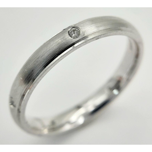 1784 - AN 18K WHITE GOLD DIAMOND SET BAND RING - FROSTED CENTRE. 3.6G. SIZE O. A/S 1172