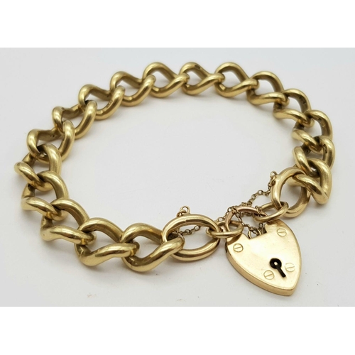 1075 - A Chunky 9K Yellow Gold Curb Link Bracelet with Heart Clasp. 18cm. 50.5g weight.