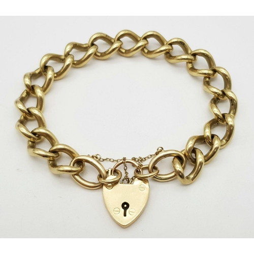 1075 - A Chunky 9K Yellow Gold Curb Link Bracelet with Heart Clasp. 18cm. 50.5g weight.