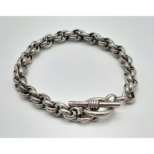 2438 - An Intricate Link Sterling Silver Bracelet. T-bar clasp. 19cm. 30g weight.