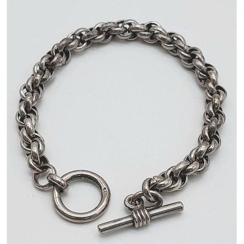 2438 - An Intricate Link Sterling Silver Bracelet. T-bar clasp. 19cm. 30g weight.