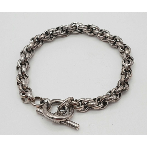 2438 - An Intricate Link Sterling Silver Bracelet. T-bar clasp. 19cm. 30g weight.