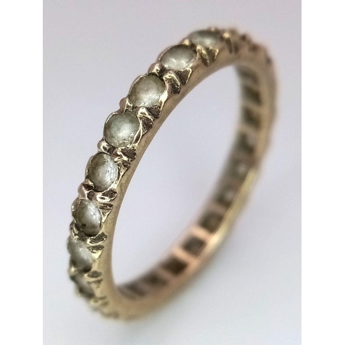 2434 - A 9K Yellow Gold Stone Set Eternity Ring. Size L. 1.75g total weight.