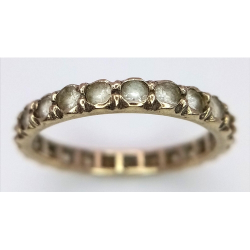 2434 - A 9K Yellow Gold Stone Set Eternity Ring. Size L. 1.75g total weight.