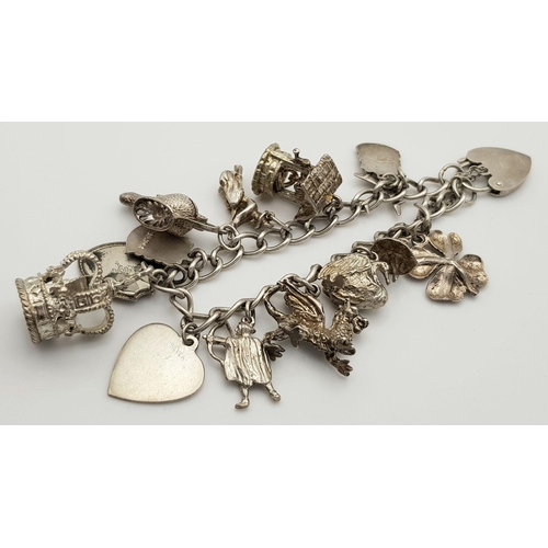 1550 - A vintage Solid Silver 925 Charm Bracelet, with 14 charms, 45.4 grams, 17.5cm, Heart padlock and saf... 