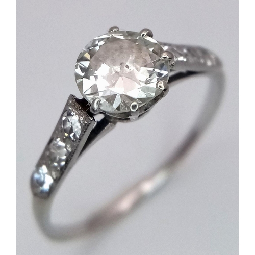 2083 - An 18K White Gold Diamond Ring. Central 1ct (approx) brilliant round cut tinted diamond with 0.15ct ... 