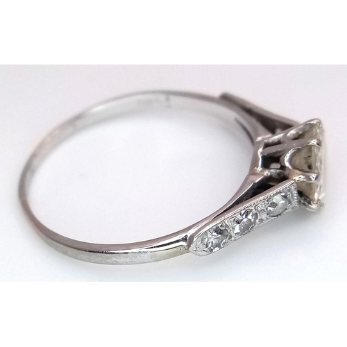 2083 - An 18K White Gold Diamond Ring. Central 1ct (approx) brilliant round cut tinted diamond with 0.15ct ... 