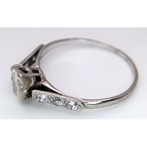 2083 - An 18K White Gold Diamond Ring. Central 1ct (approx) brilliant round cut tinted diamond with 0.15ct ... 