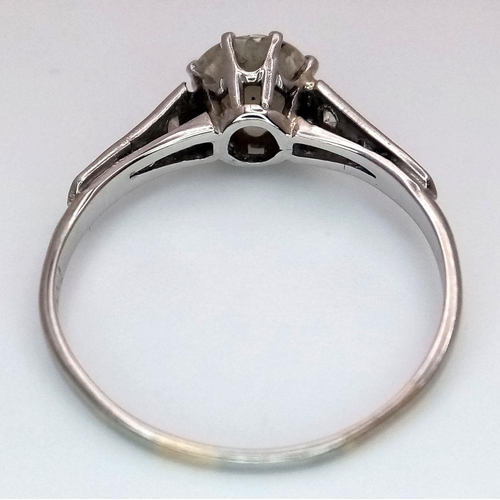 2083 - An 18K White Gold Diamond Ring. Central 1ct (approx) brilliant round cut tinted diamond with 0.15ct ... 