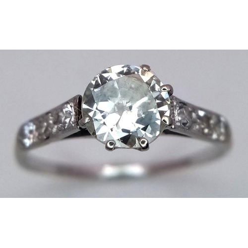 2083 - An 18K White Gold Diamond Ring. Central 1ct (approx) brilliant round cut tinted diamond with 0.15ct ... 