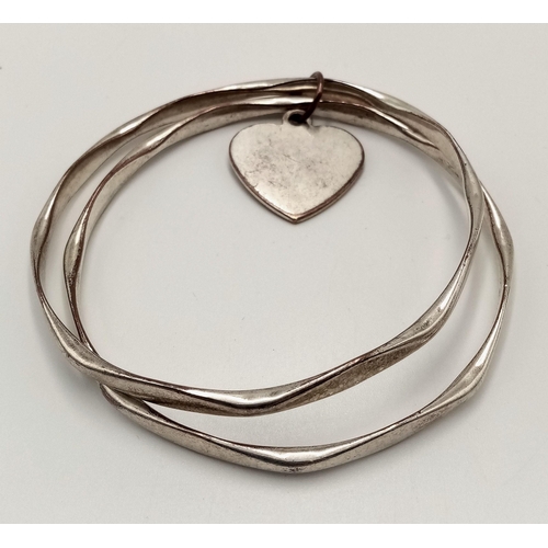 1988 - A fashion white metal double bangle with Heart charm. Diameter 7.5cm.