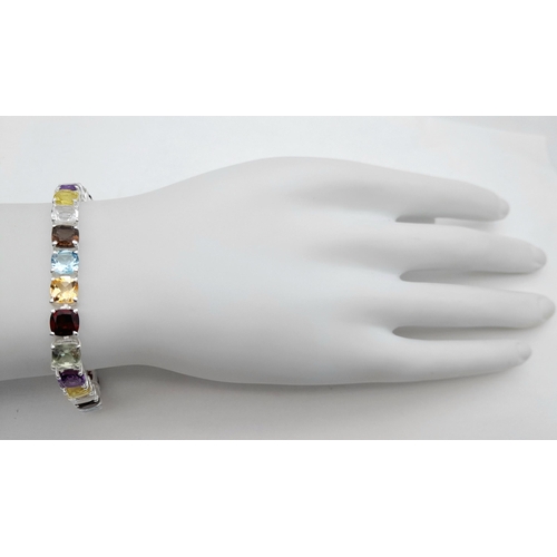 2006 - An Amethyst, Garnet, Citrine and Blue Topaz Tennis Bracelet. Set in 925 Silver. 17cm. Cd-1603