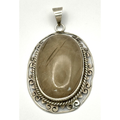 2437 - A Large Rutilated Quartz Oval Pendant - Set in Silver. 7cm.