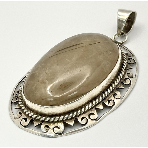 2437 - A Large Rutilated Quartz Oval Pendant - Set in Silver. 7cm.