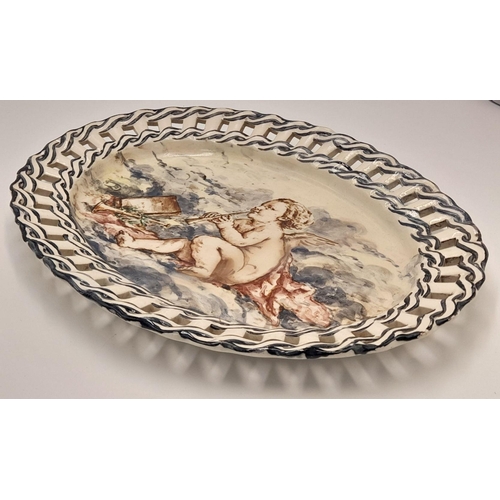 2104 - An Antique Ceramic Oval Dish with a Decorative Ribbon Style Surround. Hand-painted with a cherub 'at... 