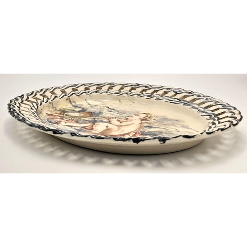 2104 - An Antique Ceramic Oval Dish with a Decorative Ribbon Style Surround. Hand-painted with a cherub 'at... 