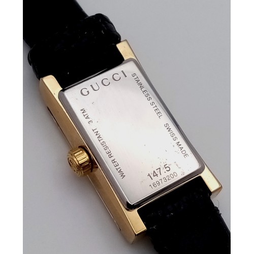 564 - A Gucci gold plated ladies quartz wristwatch with black leather strap, 14mm case diameter, in good w... 